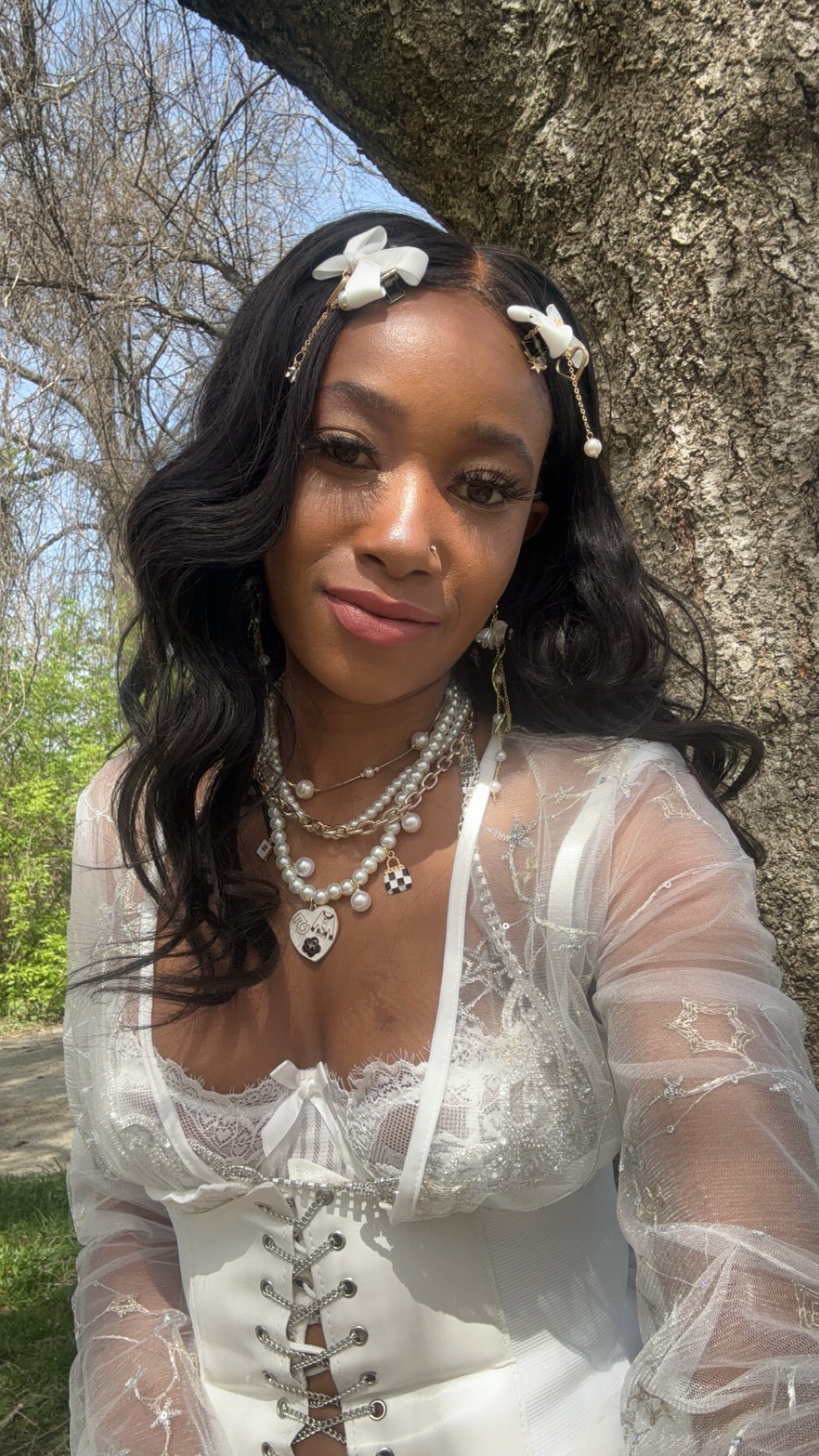 Woman in a white dress and body wave hair standing next to a tree HookedOnBundles Virgin Hair
