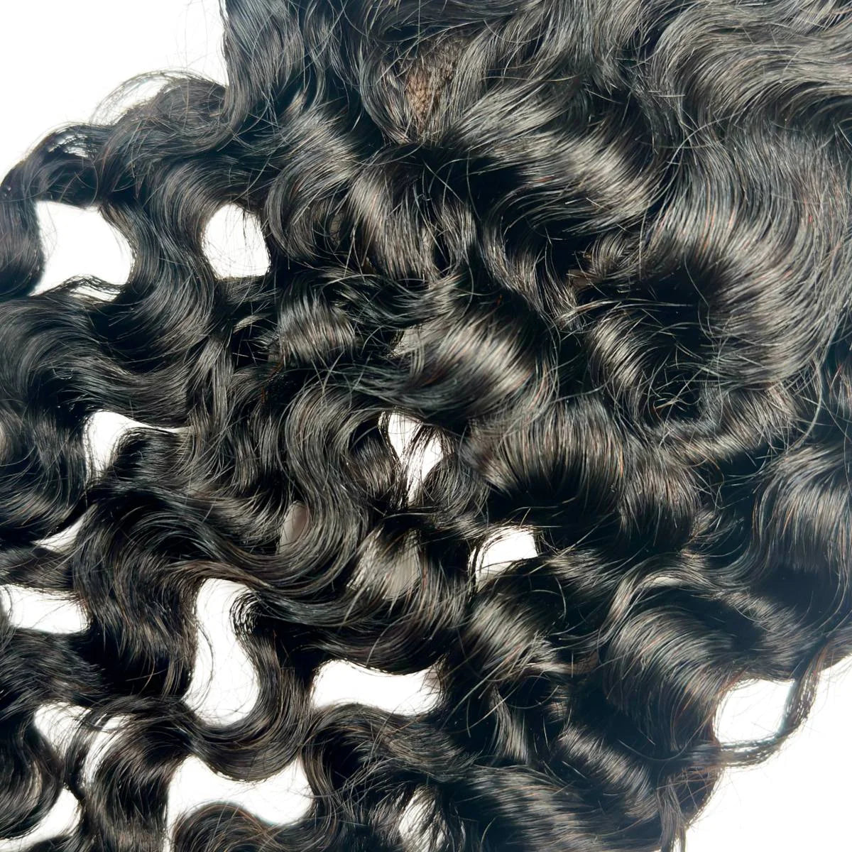 Close-up of curly black hair extensions on a white background HookedOnBundles Virgin Hair