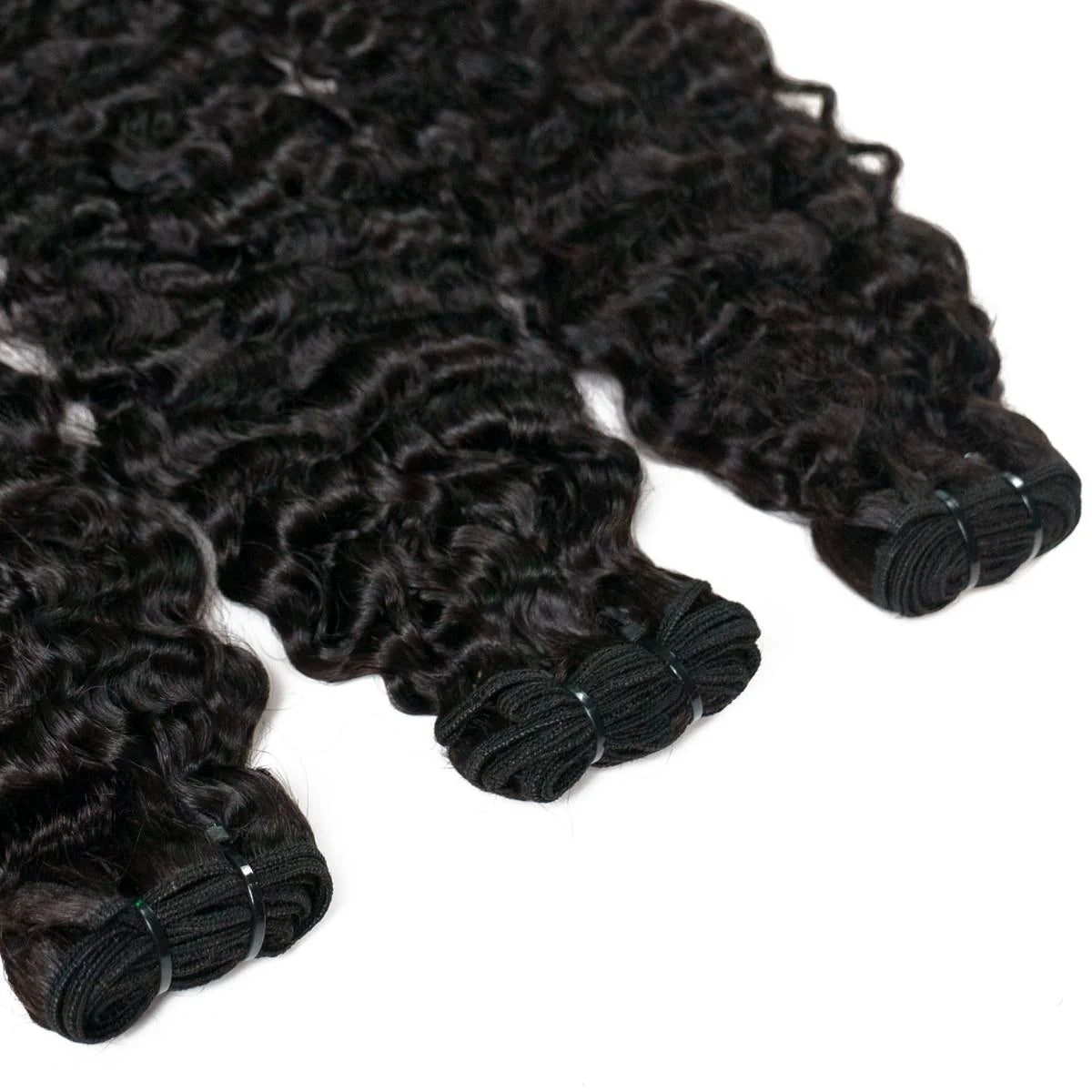 Bundles of curly black hair extensions on a white background HookedOnBundles Virgin Hair